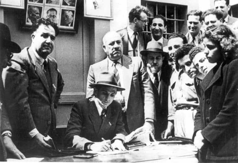 החתמת אישור העלייה הראשון על ידי ברוך דובדבני. טריפולי, 1949 זכויות יוצרים: מרכז אור שלום, בת-ים.